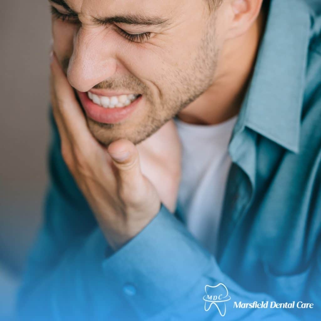 Man suffering from severe dental pain holding his cheek in agony, highlighting the need for effective dental pain relief.