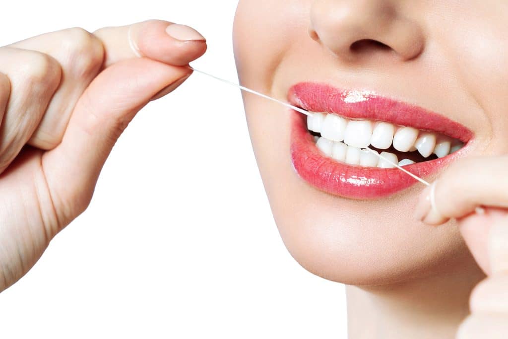 Young beautiful woman is engaged in cleaning teeth. Beautiful smile healthy white teeth.