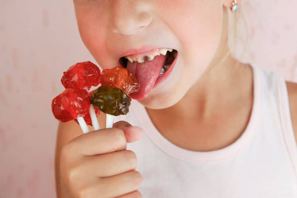 Girl has caries on teeth while eating candies|Girl has caries on teeth while eating candies|Girl has caries on teeth while eating candies