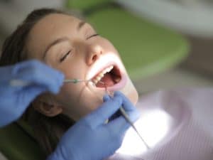 Patient receiving dental treatment while showing signs of relaxation, overcoming dental anxiety in a professional setting.