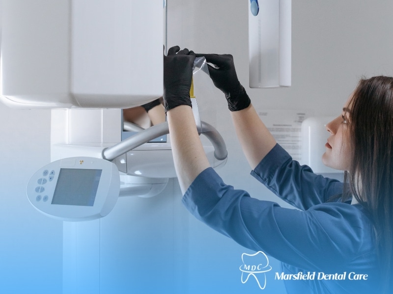Female technician preparing Dental X-ray machine for patient scan.
